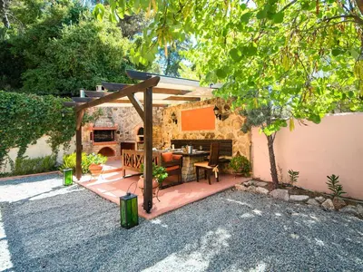 a patio with a table and a wooden pergola at Butterfly Garden Villa in Pastida