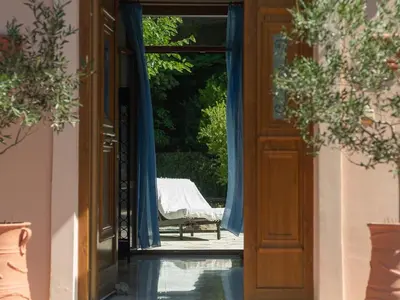 an open door leading to a patio with a hammock at Butterfly Garden Villa in Pastida