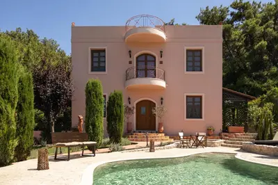 a house with a swimming pool in front of it at Butterfly Garden Villa in Pastida
