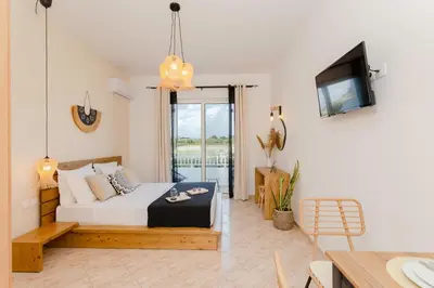 a bedroom with a bed and a tv in a room at Althea Apartments in Kolimbia