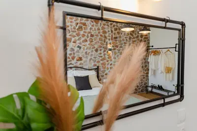 a mirror hanging on a wall next to a bedroom at Althea Apartments in Kolimbia