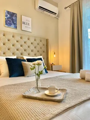a tray with a vase of flowers on a bed at Althea Apartments in Kolimbia