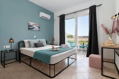 a bedroom with a bed and a balcony at Althea Apartments in Kolimbia