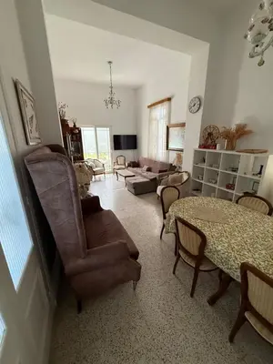 a living room with a couch and a table and chairs at Tower Traditional Pool Villa in Kremasti