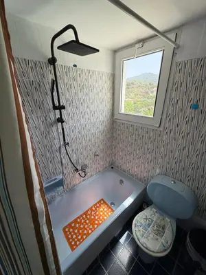a small bathroom with a tub and a window at Tower Traditional Pool Villa in Kremasti