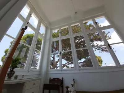 a room with large windows with a tree outside at Tower Traditional Pool Villa in Kremasti