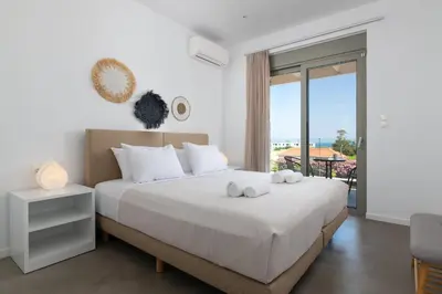a bedroom with a bed with a view of the ocean at Gennadi Harmony Suites - 200 m from the sea in Gennadi