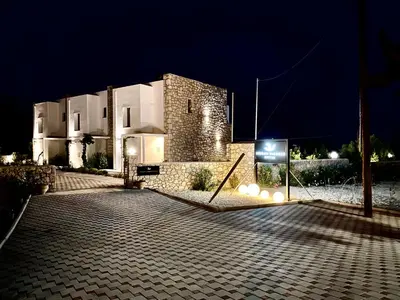a large building at night with a sign in front at Gennadi Harmony Suites - 200 m from the sea in Gennadi