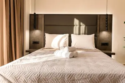 a bedroom with a large bed with towels on it at Megusta Suites in Theologos