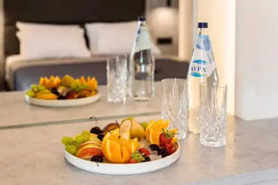 a plate of fruit on a table with a drink at Megusta Suites in Theologos