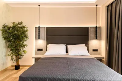a bedroom with a bed with a black headboard at Megusta Suites in Theologos