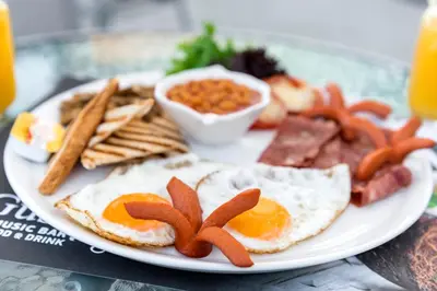 a plate of breakfast food with eggs and bacon at Megusta Suites in Theologos