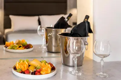 a table with two wine glasses and a plate of food at Megusta Suites in Theologos
