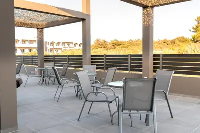 a row of tables and chairs on a patio at Megusta Suites in Theologos