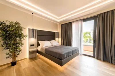 a bedroom with a bed and a large window at Megusta Suites in Theologos