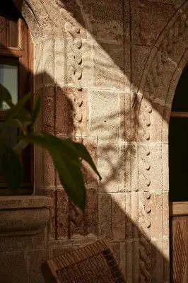 a shadow of a plant on the side of a building at AF Lindia Nature Design Hotel in Líndos