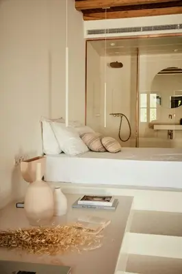 a bedroom with a bed and a table with a book at AF Lindia Nature Design Hotel in Líndos