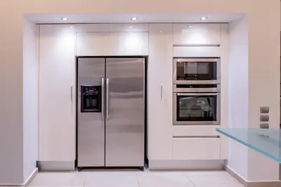 a kitchen with a stainless steel refrigerator and an oven at Dias Luxury Villa in Koskinou