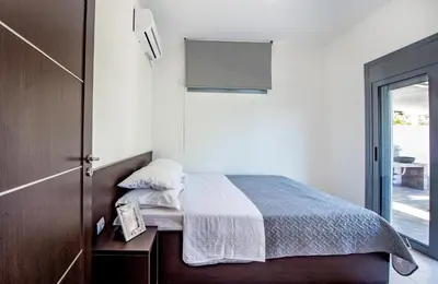 a bedroom with a bed and a door with a window at Dias Luxury Villa in Koskinou