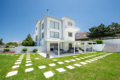 a large white house with a green yard at Dias Luxury Villa in Koskinou