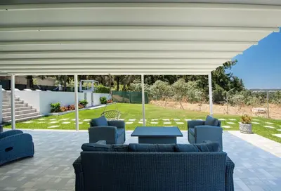 a patio with couches and a table under a pavilion at Dias Luxury Villa in Koskinou