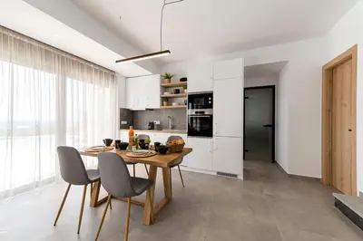 a kitchen with a wooden table and chairs at Grand Blue Villas Lachania in Lachania