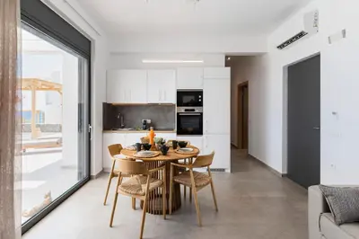 a kitchen and dining room with a table and chairs at Grand Blue Villas Lachania in Lachania