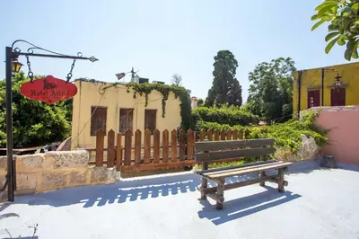 a wooden bench sitting in front of a building at Attiki Hotel in Rhodes Town