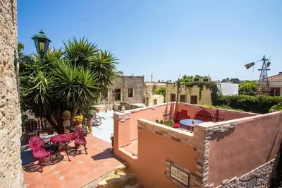 an outdoor patio with tables and chairs on a building at Attiki Hotel in Rhodes Town