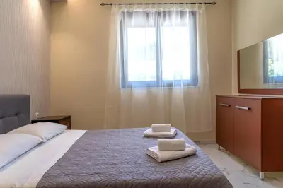 a bedroom with a bed with two towels on it at Villa Rafaella2 in Koskinou