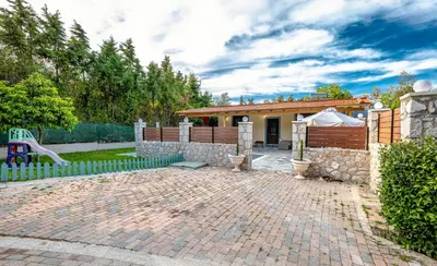 a brick patio in front of a house with a fence at Villa Rafaella2 in Koskinou
