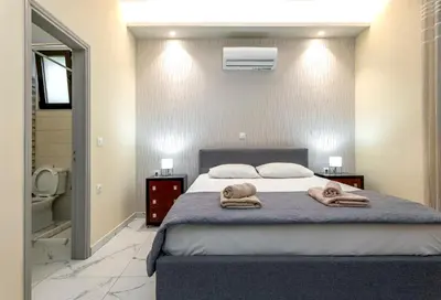 a bedroom with a bed with towels on it at Villa Rafaella2 in Koskinou