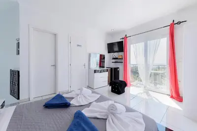 a living room with a large window with red curtains at Diamond Villa in Gennadi