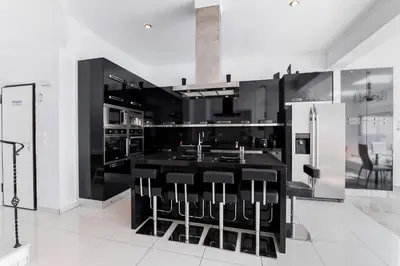 a kitchen with black cabinets and a black island with bar stools at Diamond Villa in Gennadi