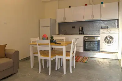 a kitchen with a table and chairs and a stove and oven at Danai House in Rhodes Town