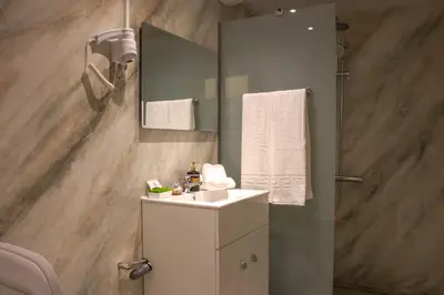 a bathroom with a white sink and a mirror at Danai House in Rhodes Town
