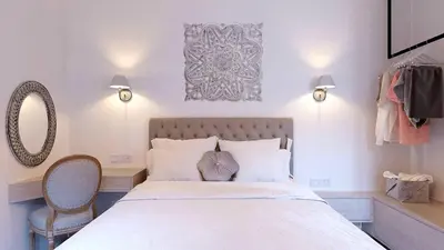 a bedroom with a bed and a desk and a mirror at Heliareti Traditional House in Koskinou
