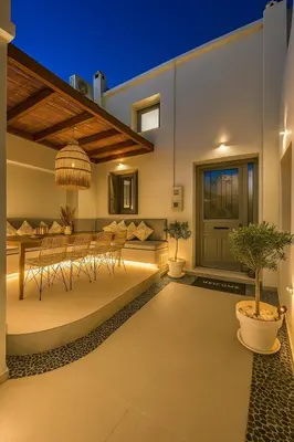 a patio with a table and chairs and a potted plant at Heliareti Traditional House in Koskinou