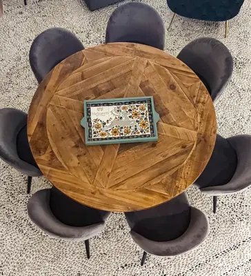 a round wooden table with chairs around it at Heliareti Traditional House in Koskinou