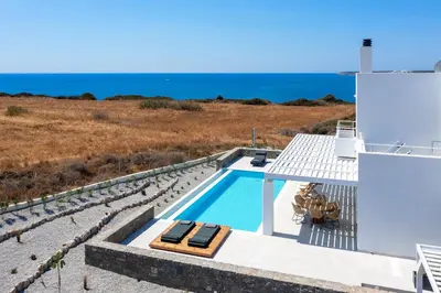a villa with a swimming pool and the ocean at Astrea Villas in Lachania