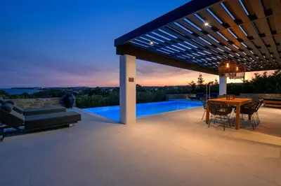 a patio of a house with a table and chairs at Astrea Villas in Lachania