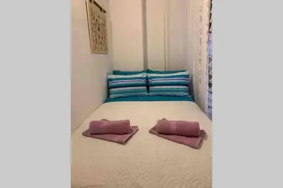 a small bed with two pink pillows on it at Beautiful historic house in Koskinou