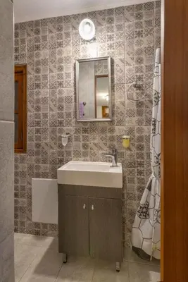 a bathroom with a sink and a mirror at Beautiful historic house in Koskinou