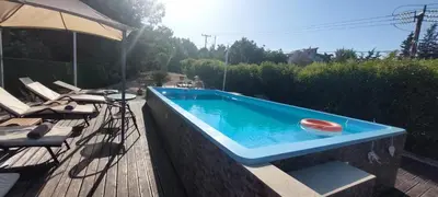 a swimming pool on a deck with an umbrella at Nila's Villa in Koskinou