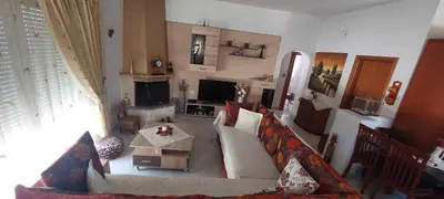 a living room with a couch and a table at Nila's Villa in Koskinou