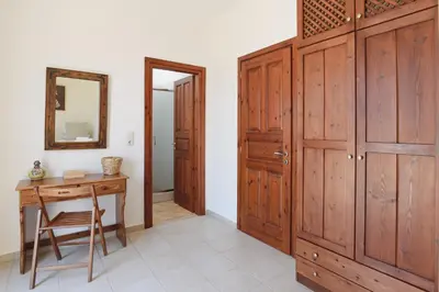 a room with a wooden closet and a table and a mirror at Villa Meitani in Kattavía