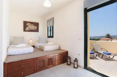 a bedroom with two beds and a balcony at Villa Meitani in Kattavía