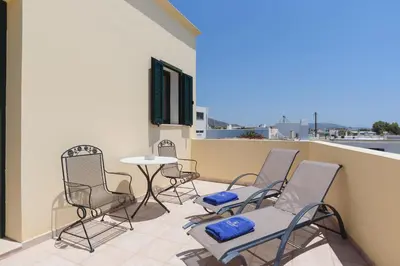 a patio with chairs and a table on a balcony at Villa Meitani in Kattavía