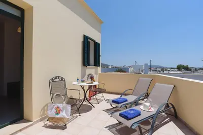 a patio with chairs and a table on a balcony at Villa Meitani in Kattavía
