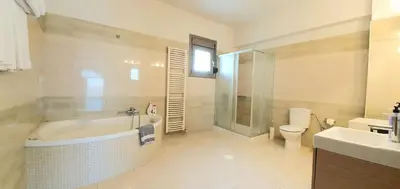 a bathroom with a tub and a toilet and a sink at Villa Cleopatra Private Heated Pool, Tennis & Football in Koskinou